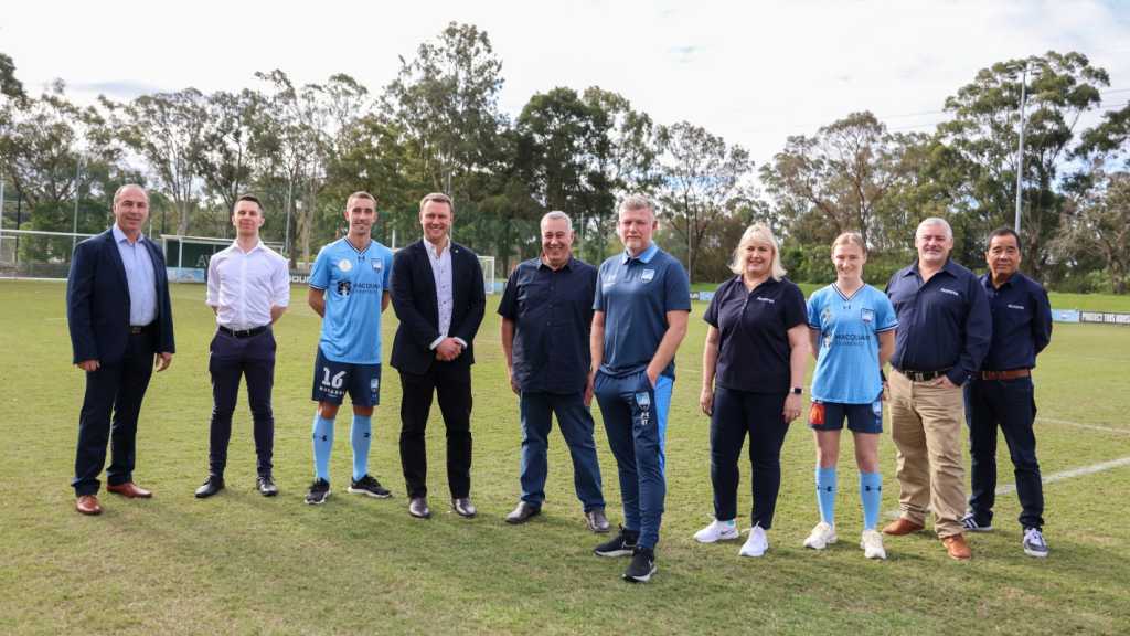 A photograph of individuals from Acronis, Hyperix and Sydney FC outside on a field.