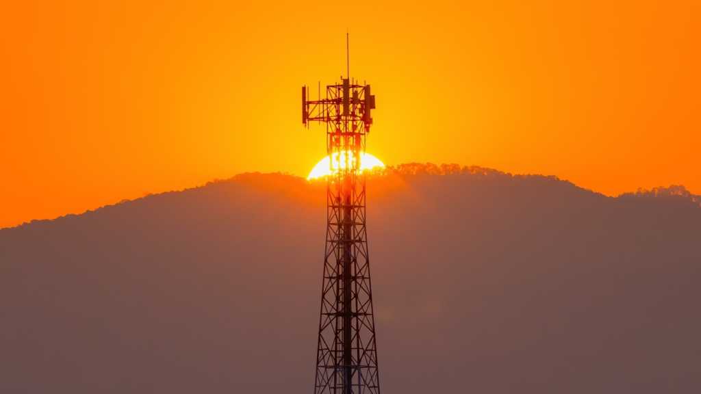 A photograph of a phone tower during sunset.